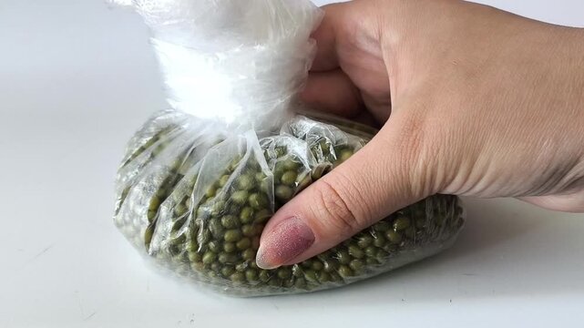 Green mung bean in a bag in his hand. Beans, legumes
