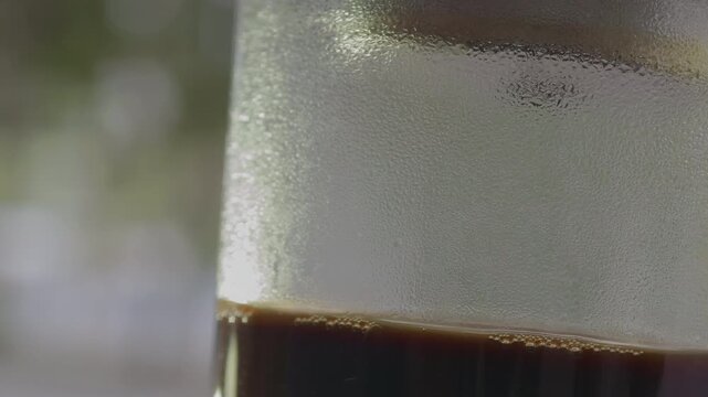 Close-up of traditional Vietnamese drip coffee phin with condensed milk at a street cafe in Ho Chi Minh City . Authentic street-side coffee preparation, natural atmosphere .