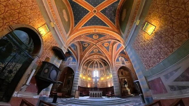 Interior of Sant Andrea church with vaulted ceiling frescoes and altar in Spello Umbria Italy