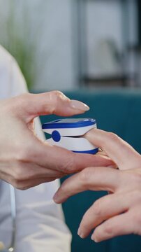 Close up of unrecognizable medical worker and patient which sitting together on couch and checking pulse and oxygen level in blood using digital gauge as oximeter