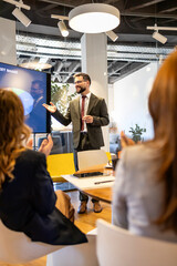 Business presenter explaining market share data during a professional meeting, group of colleagues...