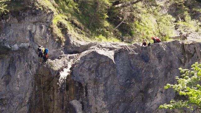 Canyoning Adventure: Group Rappelling Down a Waterfall in the Lechtal Alps