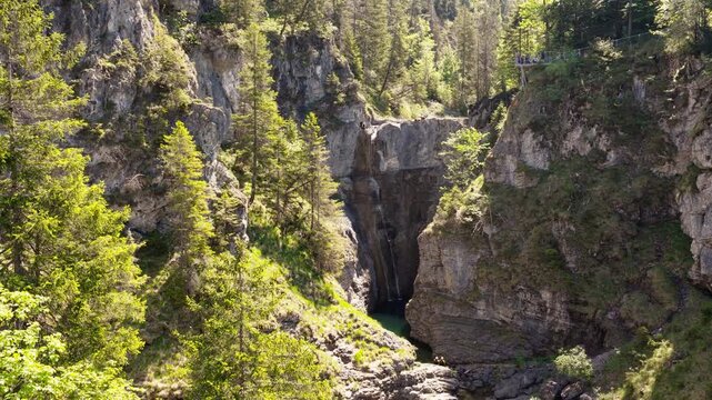 Majestic Waterfall Cascading Through a Deep Forested Gorge in the Lechtal Alps