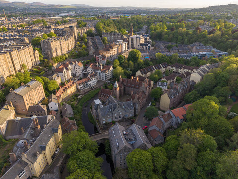 Aerial view of Dean Village with its historic stone architecture and the Water of Leith surrounded by lush greenery during golden hour Edinburgh, Scotland, United Kingdom.