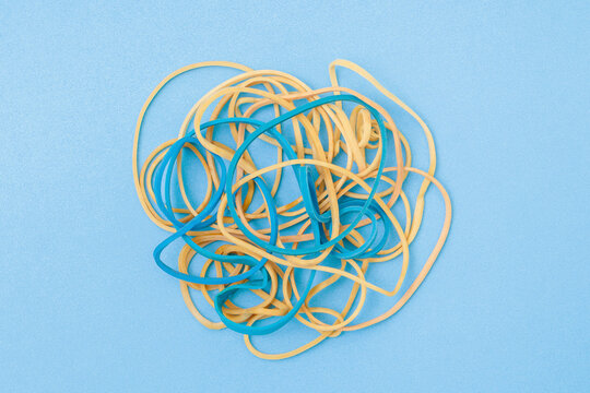 Tangled rubber bands on blue craft paper.texture.