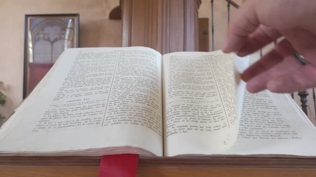 Open French Bible with red bookmark on wooden surface in elegant home interior setting
