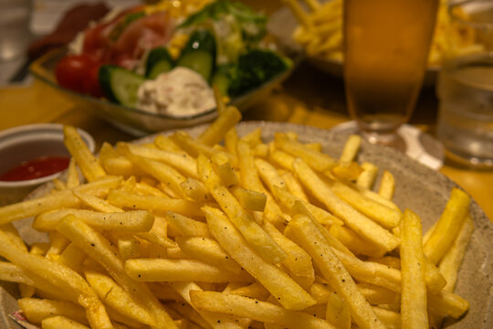 rench fries closeup with dipping sauces and salad background