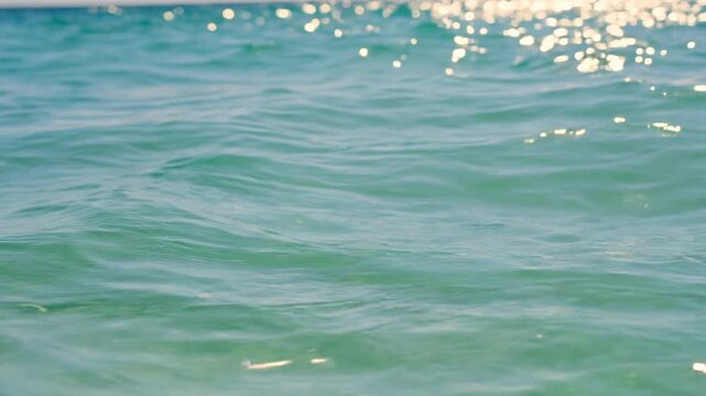 Extreme Close Up of Crystal Clear Turquoise Ocean Water with Golden Sunlight Bokeh Sparkles