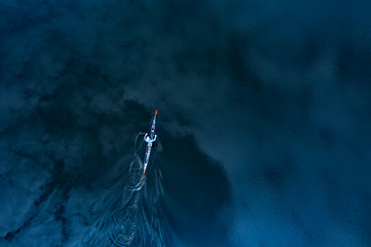 Aerial top view of a kayaker paddling in a kayak on deep blue water asset