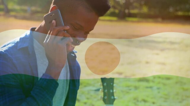 Man taking incoming call for music in park, laughing with tri overlay framing phone and guitar