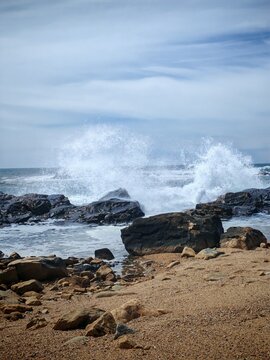 Ocean wave crashing against coastal rock on a windy beach,dramatic nature power,tormy seascape,climate chang,environmental moode,
