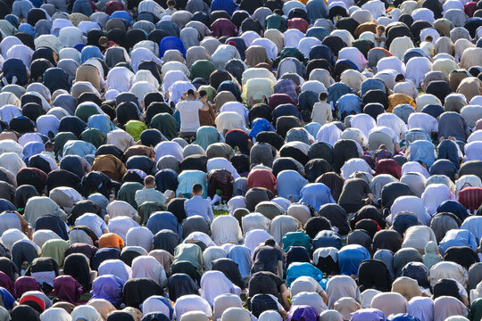Mulhouse, France - 27 May 2026: View of a large crowd of Muslim men performing prayer in prostration on the grass at Stade de l'Ill during a religious gathering.