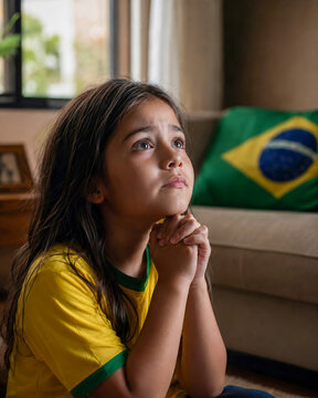Crian&ccedil;a brasileira rezando durante jogo de futebol