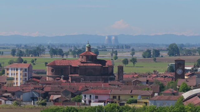 View of the historic town of San Germano Vercellese with its parish church and clock tower against a backdrop of rice fields, San Germano Vercellese, Piedmont, Italy.