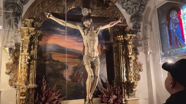 Hombre contemplando Cristo crucificado en ermita de Soria capital
