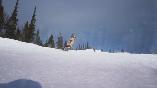 Professional rider shredding down the snowy ski slope. Covers the camera with snow. Splash snow into the lens. Snowboarder carves on the ski slope. Winter sports at the resort. Fun twist.