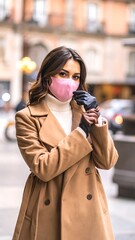 Obraz premium Woman wearing pink face mask outdoors.