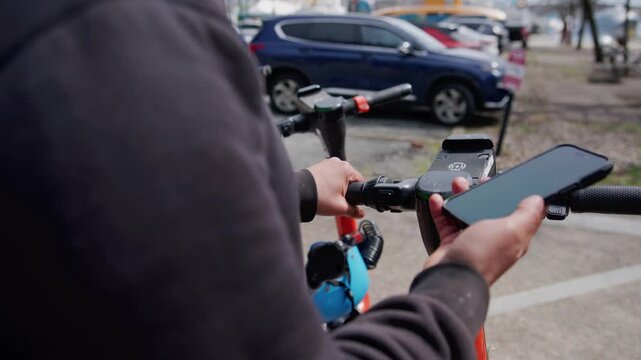 In a lively urban setting, a man grips his smartphone, navigating its features with ease. He stands among colorful scooters, immersed in modern technology and daily life