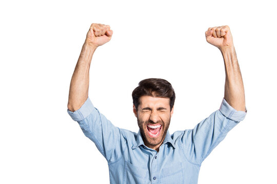 Photo of arab guy celebrating lottery winning raising arms up rejoicing yelling of incredible feelings wear casual denim shirt isolated white color background