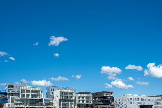 Open sky dominates La Confluence, Lyon, France above a low line of modern buildings, balancing clouds, skyline, and urban architecture