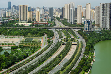 Wide aerial panorama of modern Hanoi skyline featuring multilane roads, residential towers, and green urban landscapes beside a lake. © Hanoi Photography