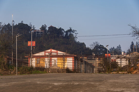 Quiet border checkpoint buildings near the Vietnam China frontier surrounded by hills and rural infrastructure during soft evening light.