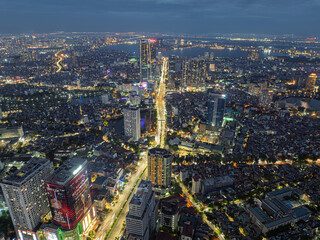 Obraz premium Night aerial panorama of Nguyen Chi Thanh Street with illuminated traffic corridors and dense Hanoi urban skyline.