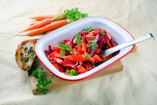 Easy homemade carrot salad with marinated carrots and beets served as close-up in a design bowl