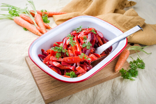 Easy homemade carrot salad with marinated carrots and beets served as close-up in a design bowl
