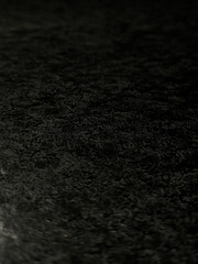 Fototapeta premium Close-up of a black rough surface with a pronounced material texture. Minimal abstract background.