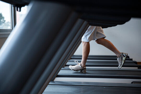 Man Running on a Treadmill in a Modern Fitness Studio