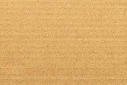 Brown Corrugated Cardboard Texture Background,Macro,Close-up full frame shot of a light brown corrugated cardboard sheet, highlighting the natural paper fiber texture and parallel embossed ridges.