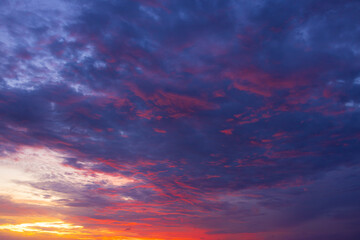 Fototapeta premium Dramatic golden hour sky with colorful sunset clouds,A breathtaking panoramic view of a dramatic golden hour sky, featuring vibrant orange, pink, and purple sunset clouds scattered across a deep blue 
