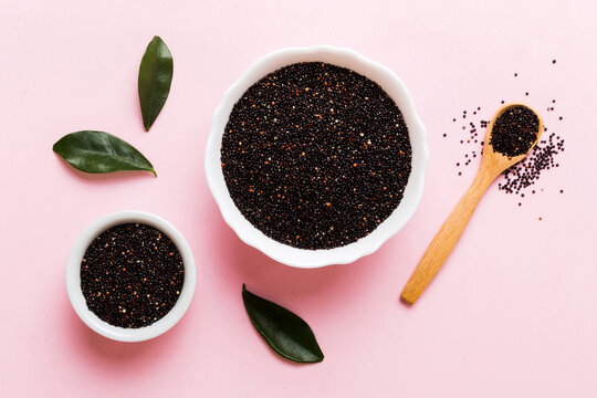 quinoa seeds in bowl and spoon on colored background. Healthy kinwa in small bowl. Healthy superfood