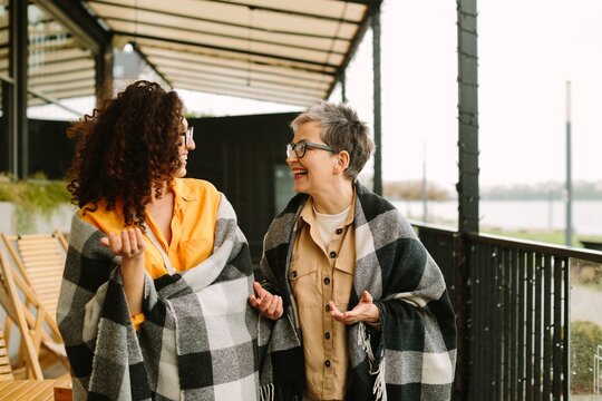 Cheerful women enjoying friendship, walking outdoors, laughing together