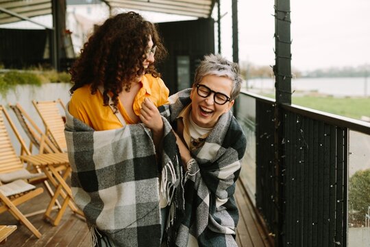 Generational friends laughing together on a terrace