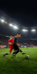 Naklejka premium Soccer players sprinting for ball with dramatic motion blur in night stadium. Concept of football training, match promo, sports academy, cleats advertising and tournament media.