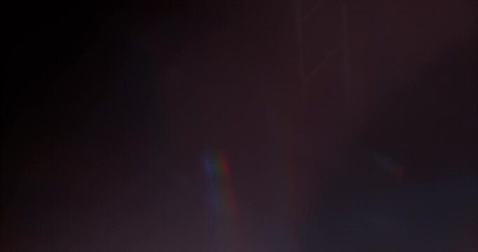 Slow motion of lens flare isolated on black background. Colored spectrum. Cinematic glowing light overlay with optical streaks and rays for VFX compositing and transitions.