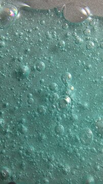Blue cream liquid gel serum flowing down on silver texture, makeup and cosmetics background, skincare or hair product