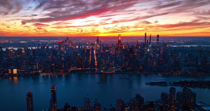 Jaw-dropping panorama of New York City against bright colorful sky. City lights of Manhattan at dusk time from drone.