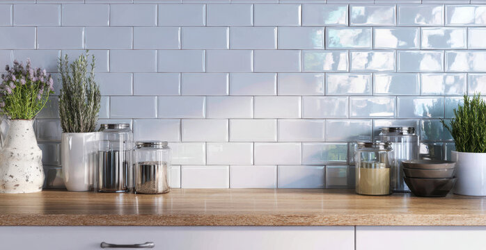 Handmade white subway tiles create a modern kitchen backsplash above a wooden countertop with decorative jars and plants in a contemporary setting