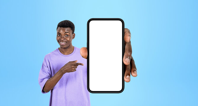 Person pointing at a smartphone mockup with empty screen, minimal style on blue backdrop, concept of online app display