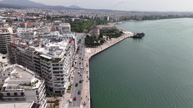 Aerial forward flyover of the White Tower and waterfront in Thessaloniki, Greece