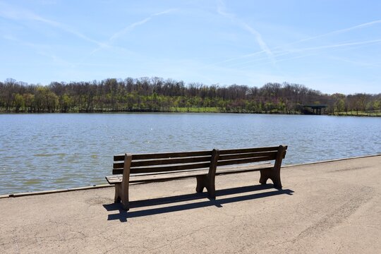 The empty park bench at the lake in the park.