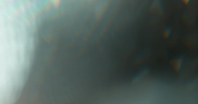 Slow motion of lens flare isolated on black background. Colored spectrum. Cinematic glowing light overlay with optical streaks and rays for VFX compositing and transitions.