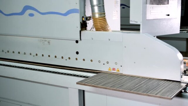 Worker Processing Laminated Wood Panel in Factory
