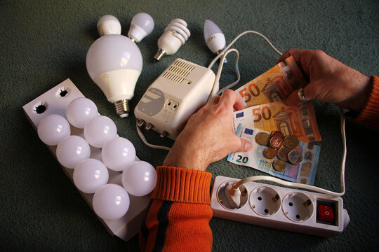 Electricidad, pobreza energ&eacute;tica, bombilla, enchufe y dinero factura luz el&eacute;ctrica