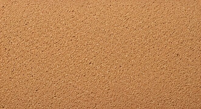 Uniform granular light brown texture background, fine particles close-up
