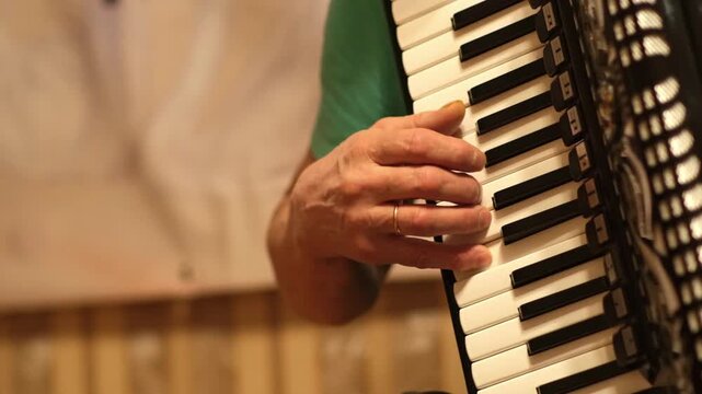 Musician plays the accordion while showcasing skills and sharing music with friends in a warm and inviting setting during the day.