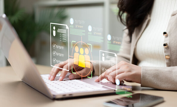 Businesswoman analyzing candidate recruitment data on laptop with virtual HR interface, representing employee screening, talent acquisition, digital hiring, and workforce management.